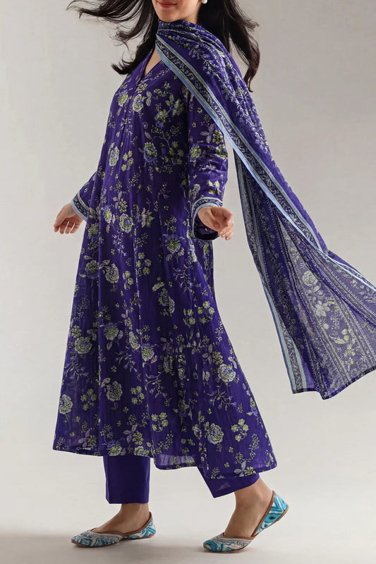 Woman wearing a traditional purple outfit with a matching dupatta on a plain background