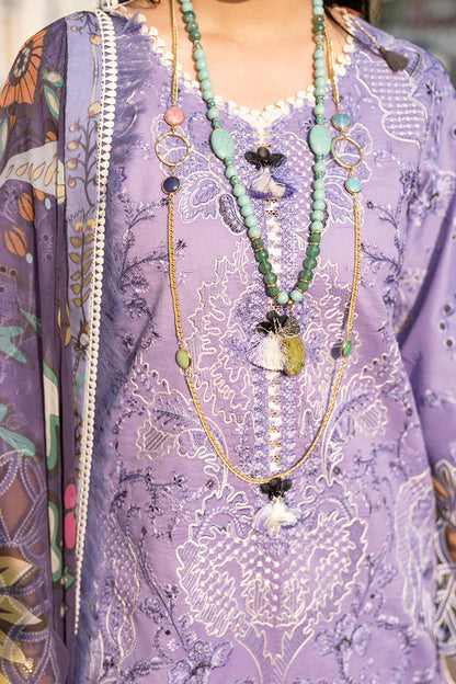 Close-up of a person wearing a purple patterned garment with a long necklace.