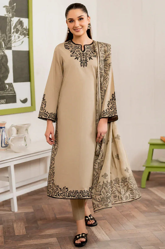 Woman wearing a beige embroidered outfit with a matching dupatta in a room setting.