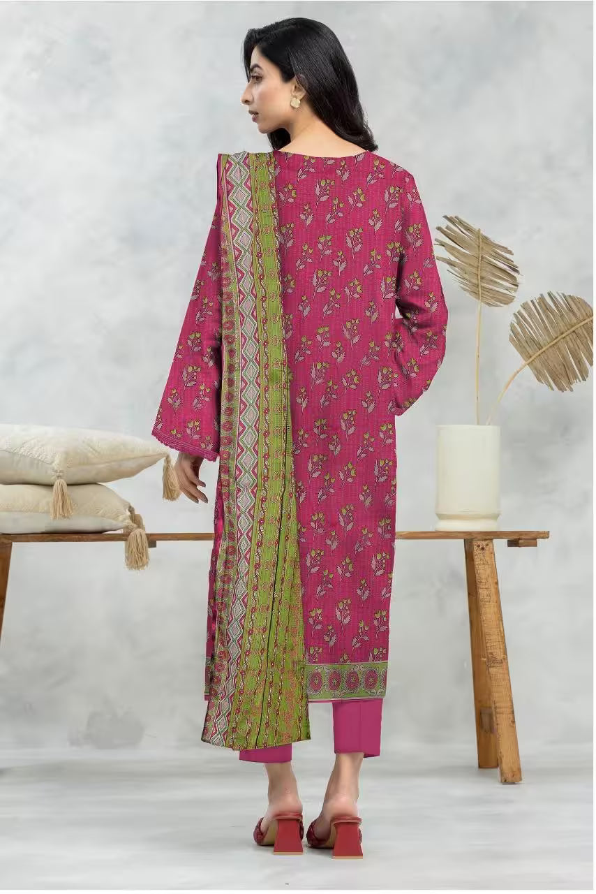 Woman wearing a pink and green traditional outfit in a minimalistic setting.