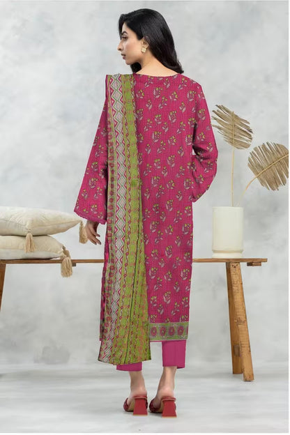 Woman wearing a pink and green traditional outfit in a minimalistic setting.