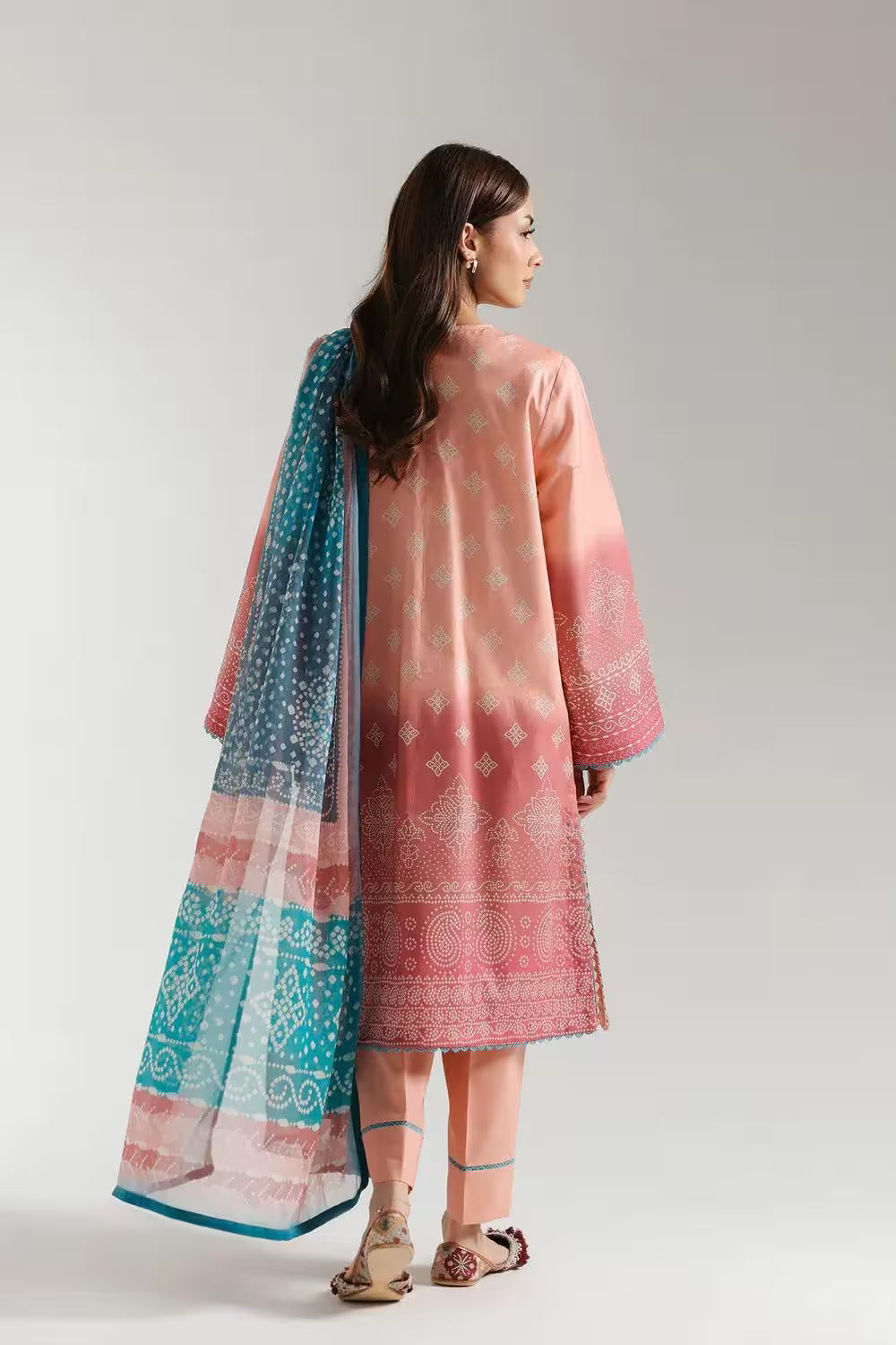 Woman wearing a pink and blue traditional outfit with a white background