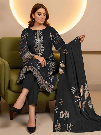 Woman sitting on a green chair holding a black dupatta with floral patterns in a well-lit room.