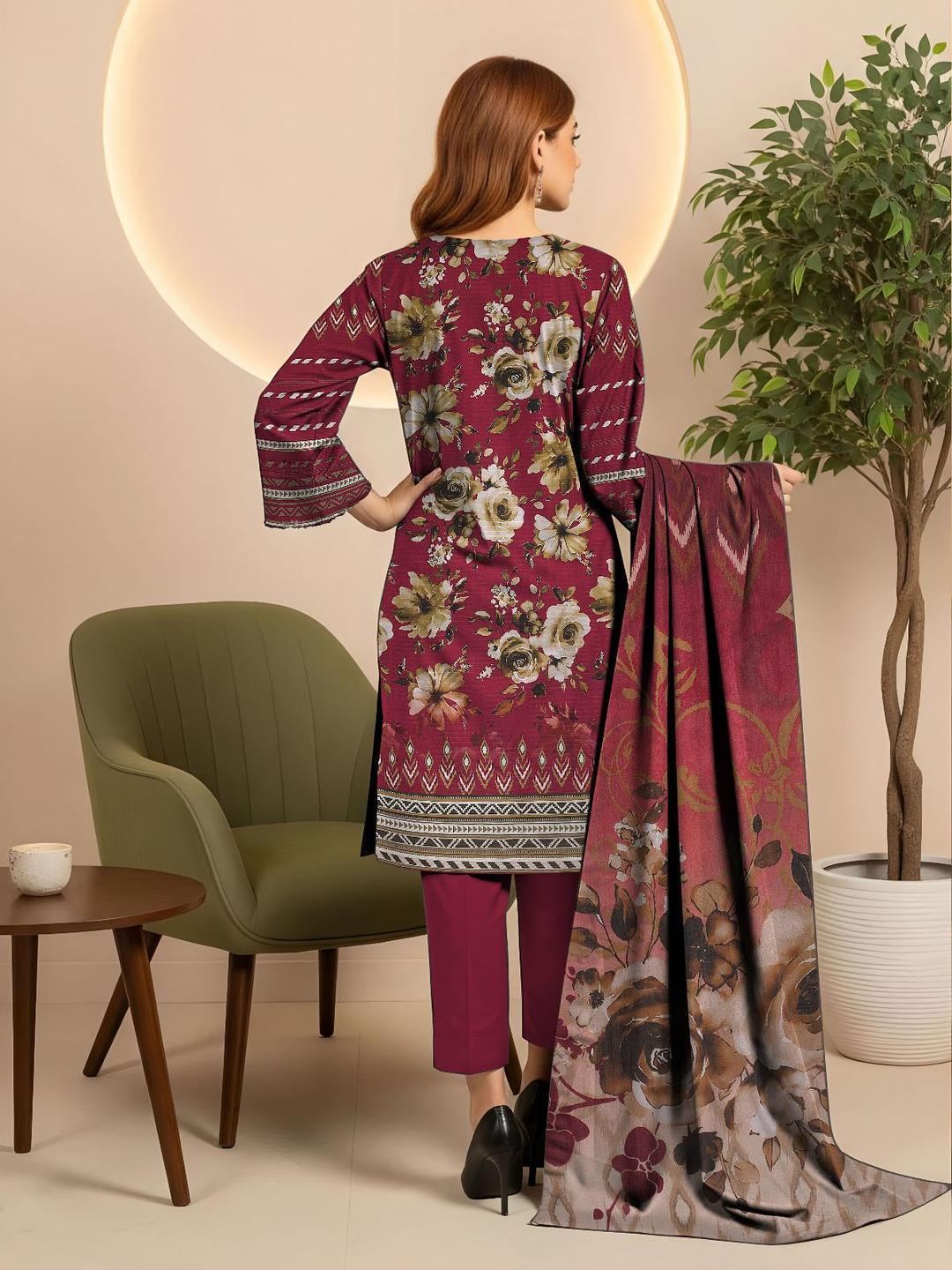 Woman in a floral dress with a matching scarf in a room with a green chair and plant.