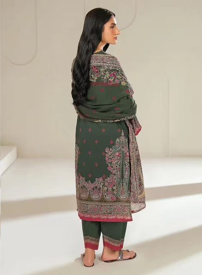 Woman wearing a green traditional outfit with floral patterns in a minimalistic setting