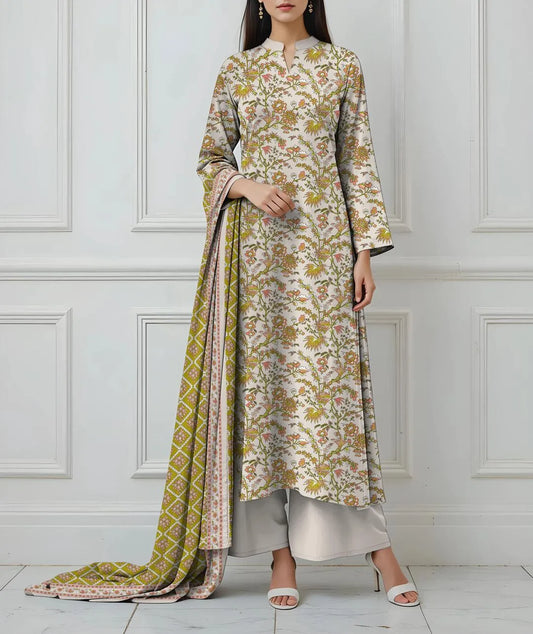 Woman wearing a floral kurta with a matching dupatta against a white paneled wall.