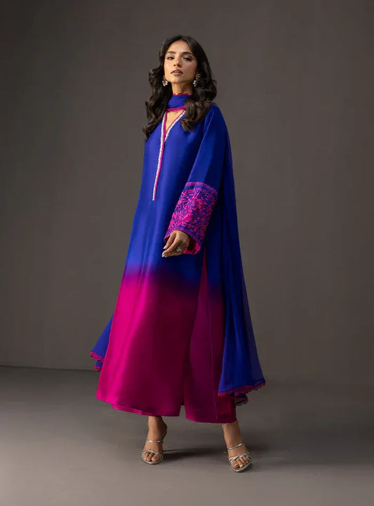 Woman wearing a blue and pink traditional outfit against a gray background