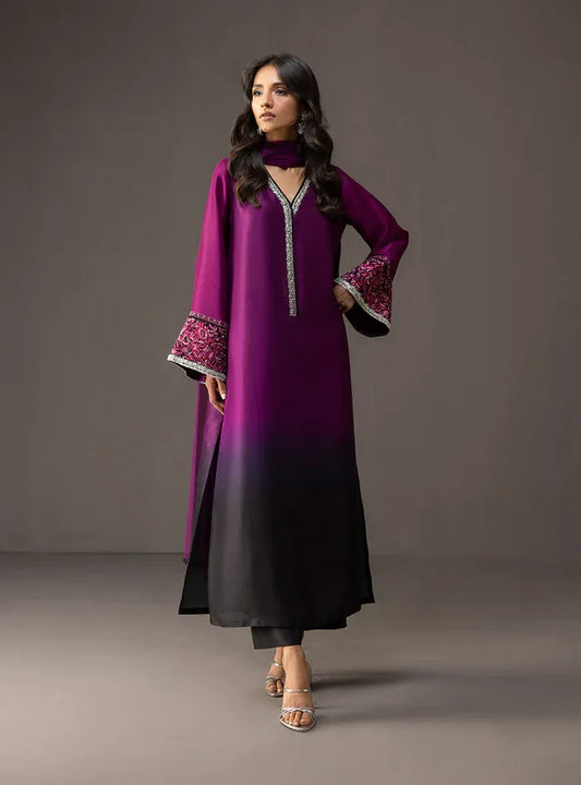 Woman wearing a purple and black dress with floral embroidery on a gray background