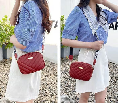 Person wearing a blue checkered shirt and white skirt with a red quilted bag outdoors.