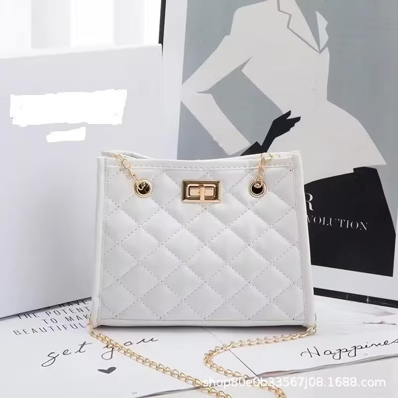 White quilted handbag with gold chain on a magazine background
