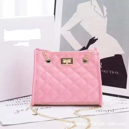 Pink quilted handbag with gold chain on a magazine background