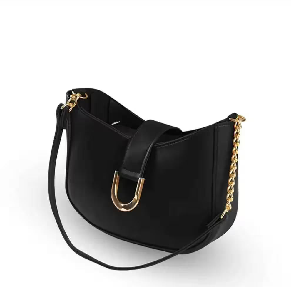 Black handbag with gold accents on a white background