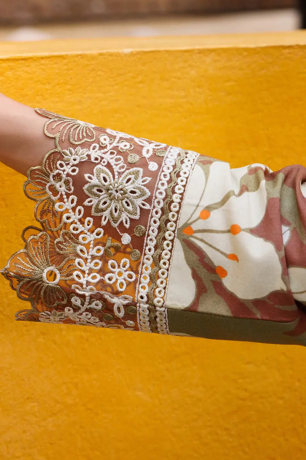 Close-up of a hand with intricate henna design on an orange background