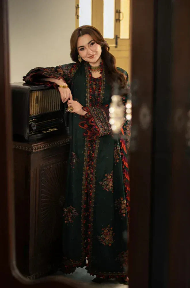 Woman in a long, dark floral dress standing in a room with vintage decor.