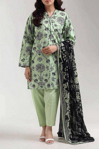 Woman wearing a green floral outfit with a black and white scarf on a white background