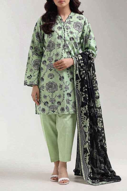 Woman wearing a green floral outfit with a black and white scarf on a white background