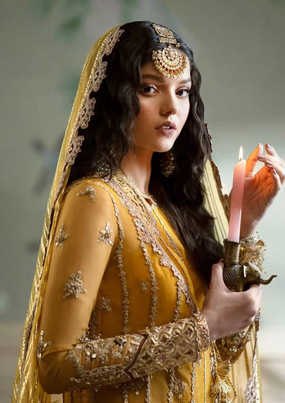 Woman in traditional yellow and gold outfit holding a lit candle