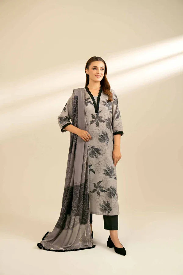 Woman wearing a gray floral dress with a matching dupatta on a beige background