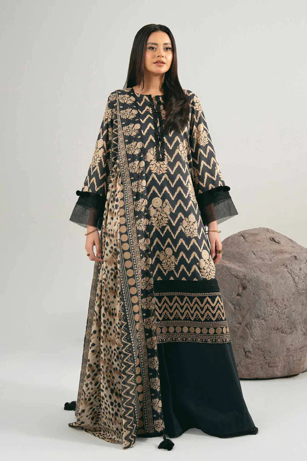 Woman wearing a long, patterned dress with a black skirt against a neutral background