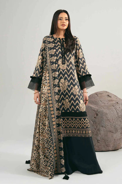 Woman wearing a long, patterned dress with a black skirt against a neutral background