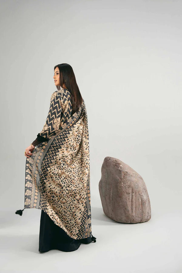 Woman wearing a patterned dress with a cheetah print, standing against a plain background.