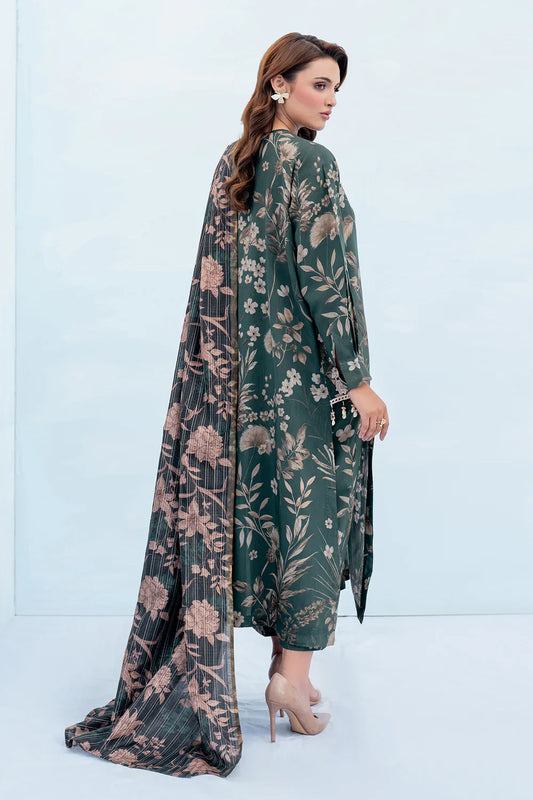 Woman wearing a green floral dress with a sheer overlay against a light blue background