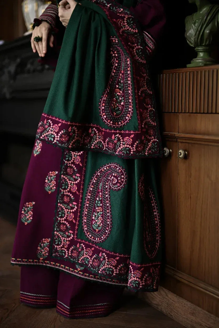 Person wearing a traditional outfit with intricate patterns in a dimly lit room.