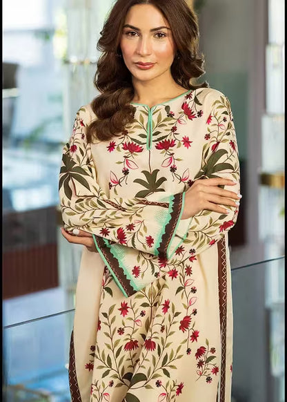 Woman wearing a cream-colored embroidered dress with floral patterns indoors.