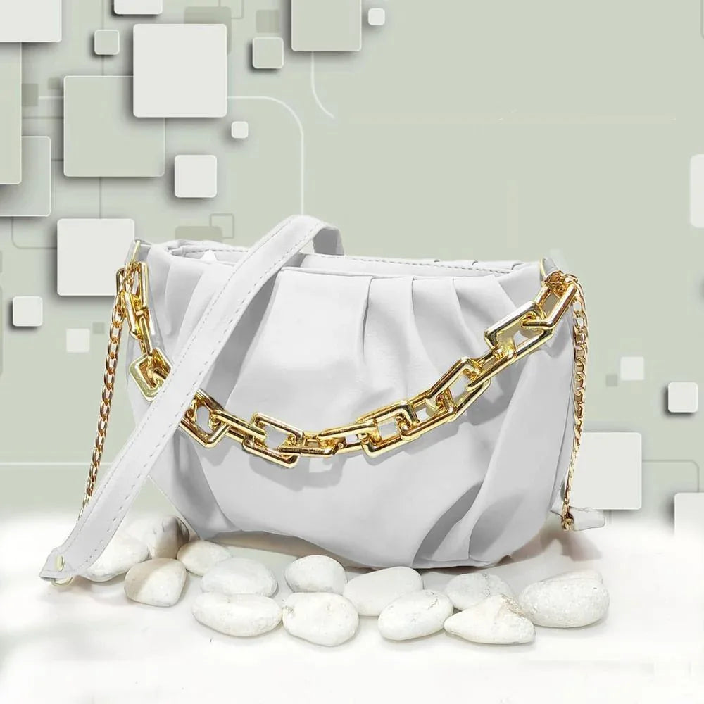 White handbag with gold chain detail on a light gray background