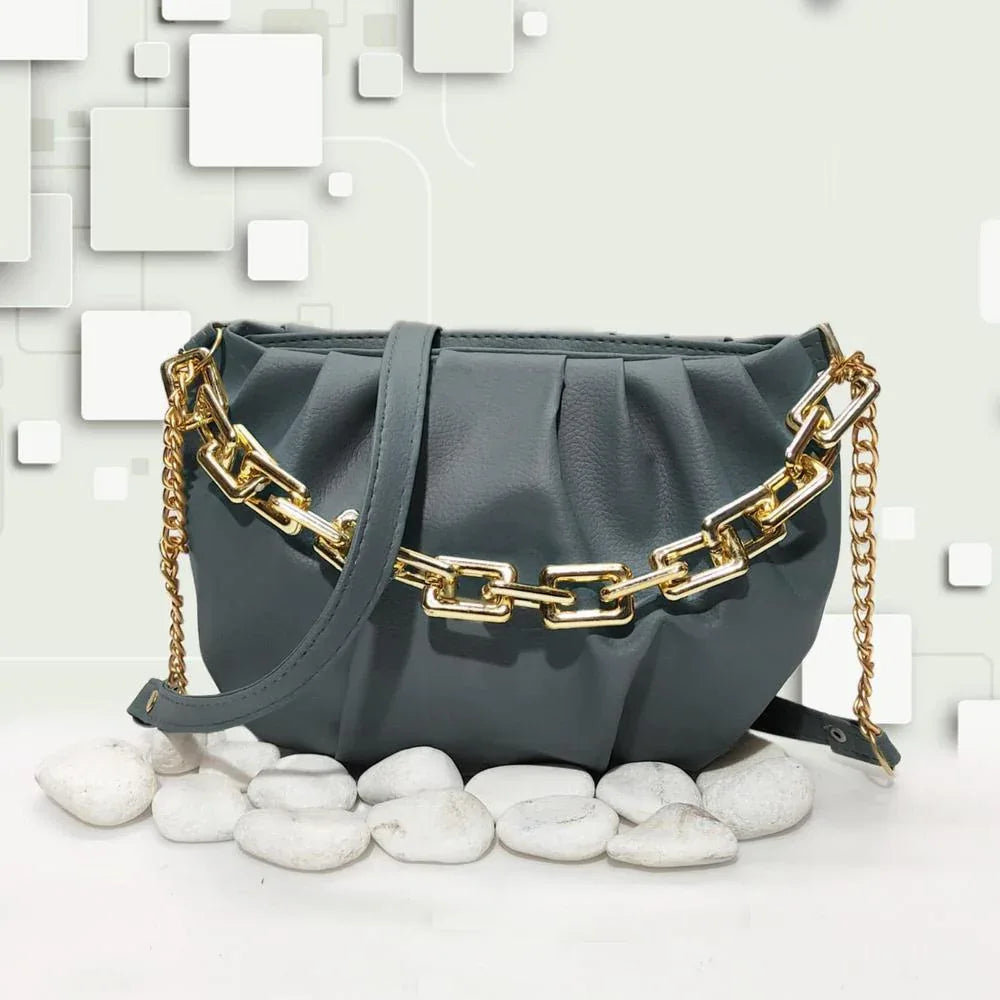 Gray handbag with gold chain strap on a light background