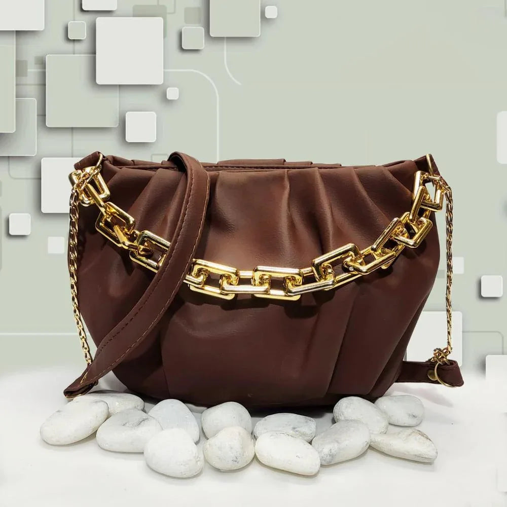 Brown handbag with gold chain strap on a light background