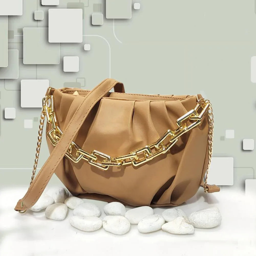 Beige handbag with gold chain detail on a light gray background