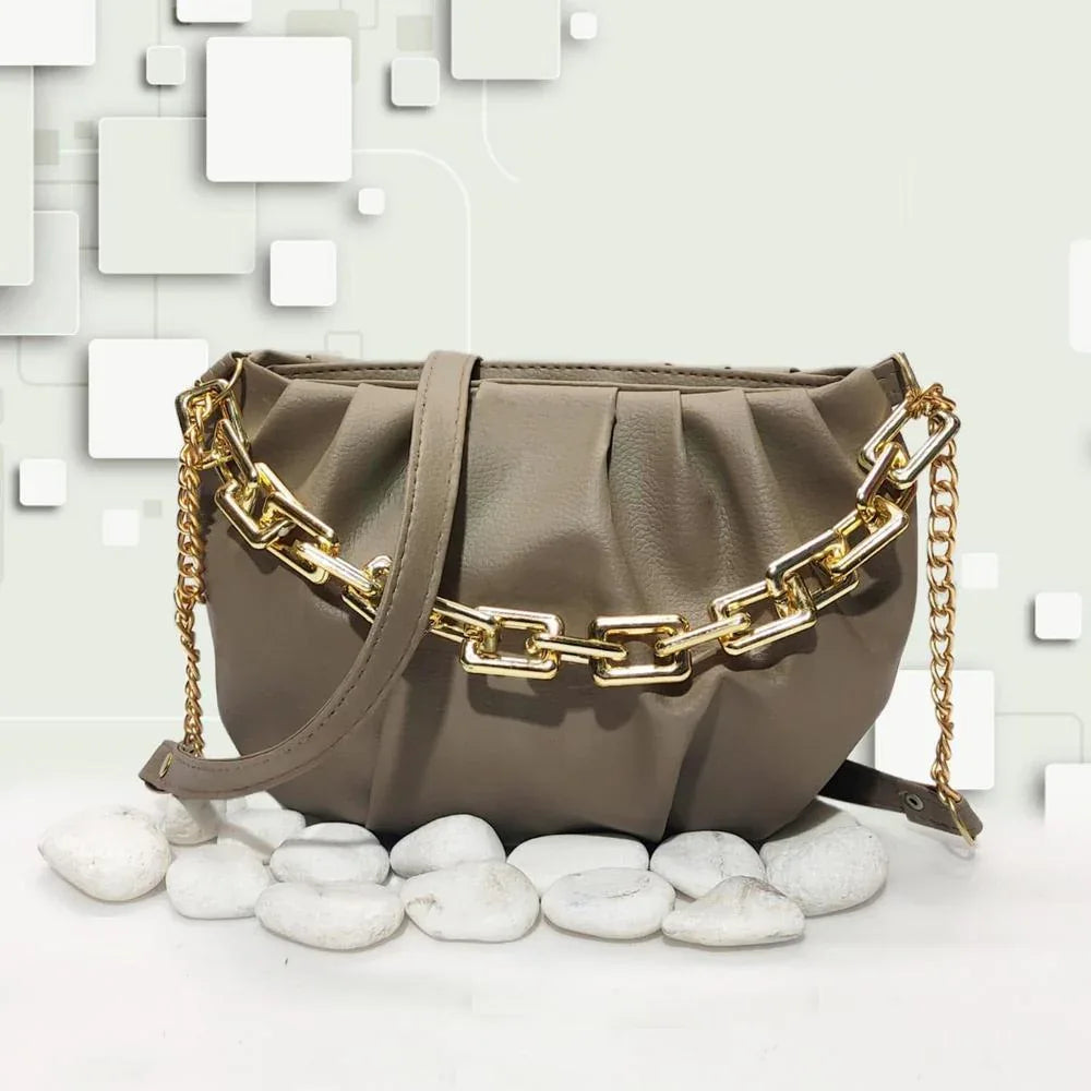 Brown handbag with gold chain strap on a light background