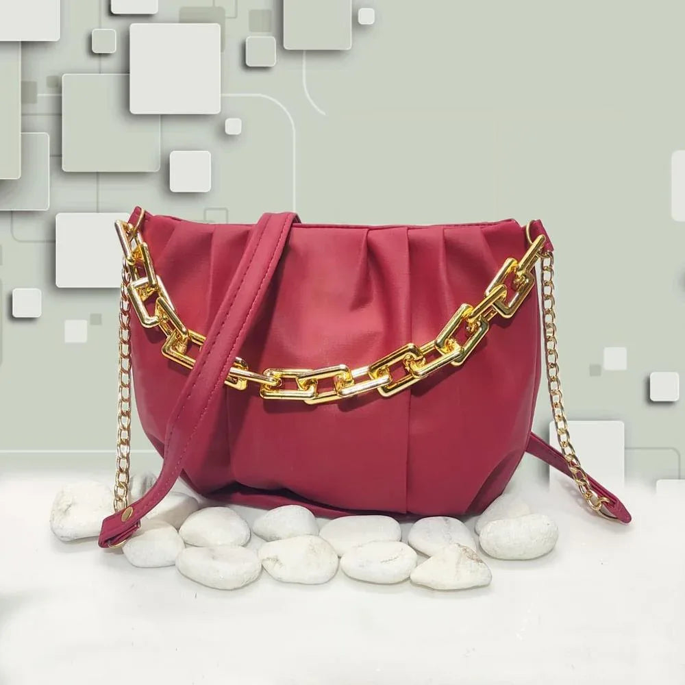Red handbag with gold chain detail on a light gray background