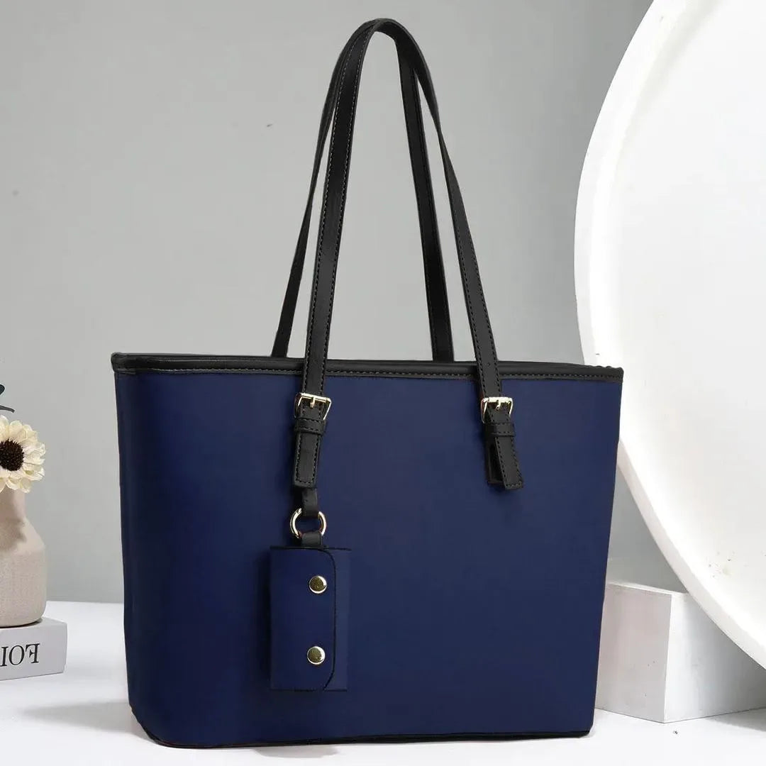 Blue handbag with black straps on a gray background