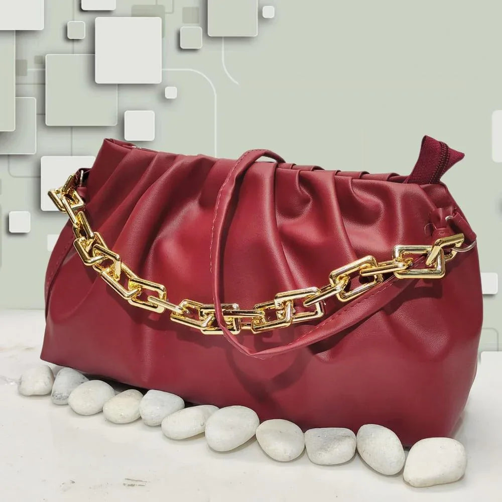 Red handbag with gold chain strap on a light gray background