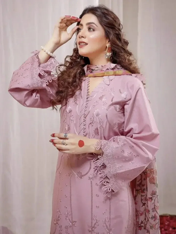 Woman wearing a pink embroidered outfit with a plain background