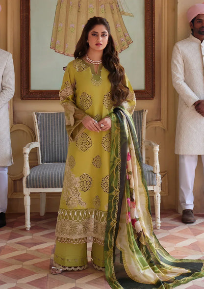 Woman in a yellow traditional outfit with a green dupatta in an indoor setting
