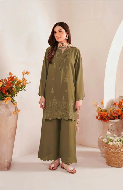 Woman wearing a green outfit with floral patterns in a decorated indoor setting.