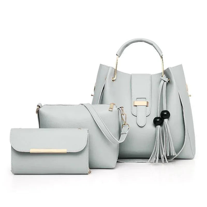 Set of light gray handbags with tassels on a white background