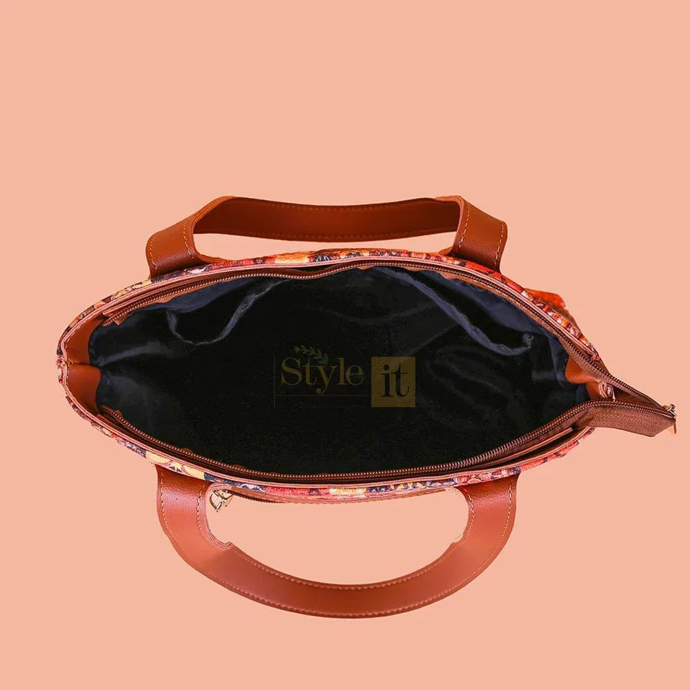 Handbag with floral pattern on a peach background, featuring the brand 'The Style it'.