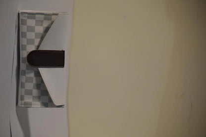 Small checkered mat with a black object on a light-colored floor