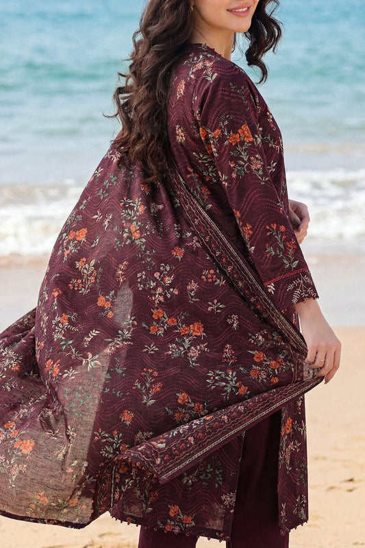 Woman wearing a burgundy floral dress on a beach