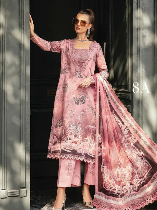 Woman in a pink embroidered outfit standing in front of a door.