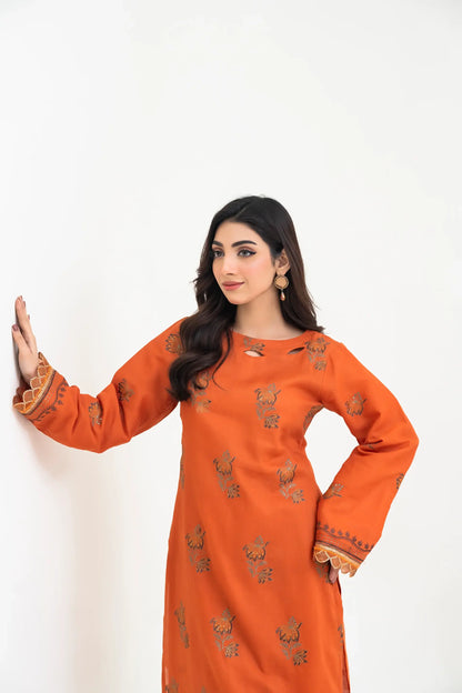 Woman wearing an orange traditional outfit with patterns on a white background
