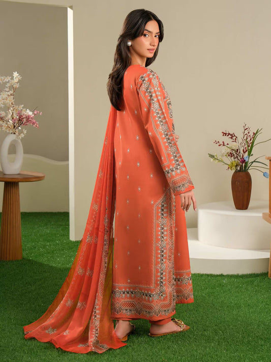 Woman wearing an orange traditional outfit with intricate patterns in a home setting.