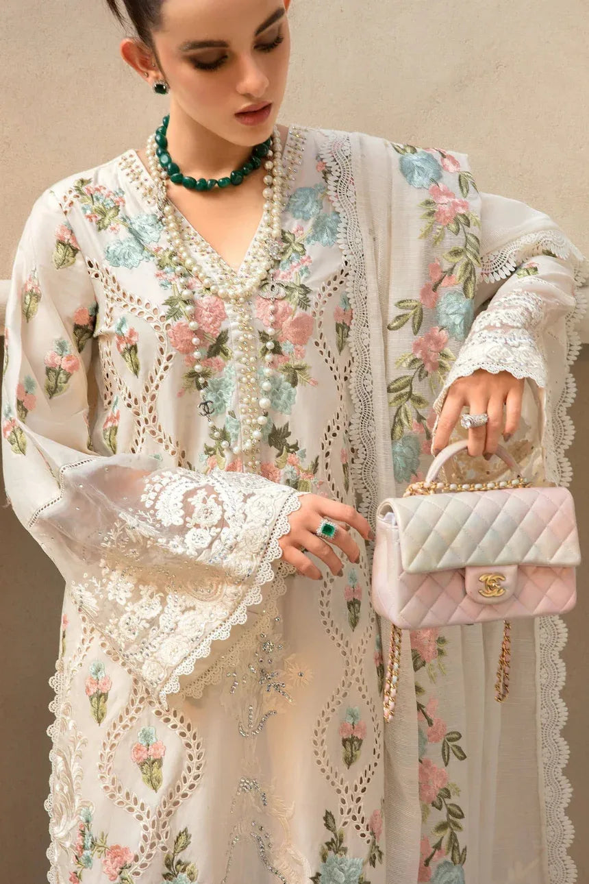 Woman in a floral embroidered outfit holding a pink handbag.