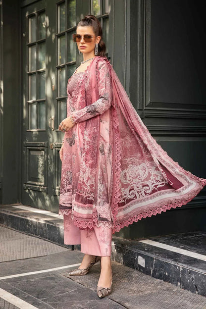 Woman in a pink embroidered traditional outfit standing on a staircase.