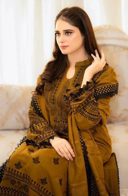 Woman wearing a mustard yellow embroidered outfit sitting on a couch.