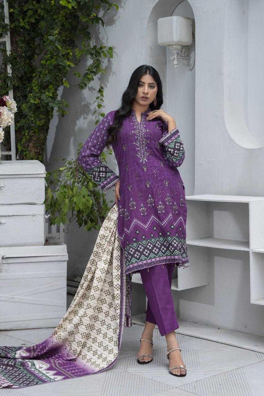 Woman wearing a purple embroidered traditional outfit in an indoor setting with white walls and greenery.